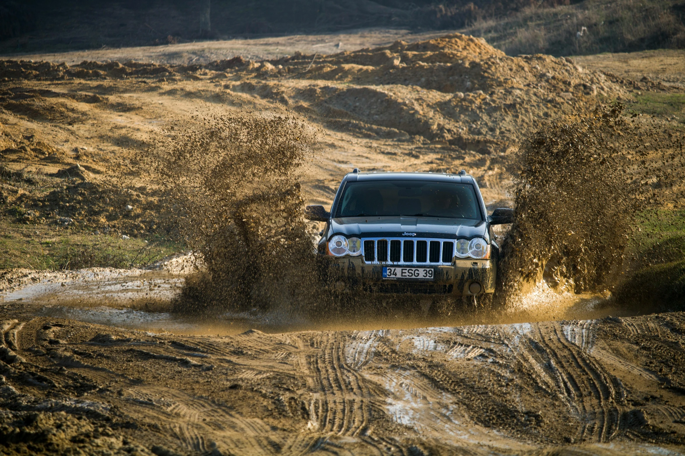 a suv driving through mud dles in the country