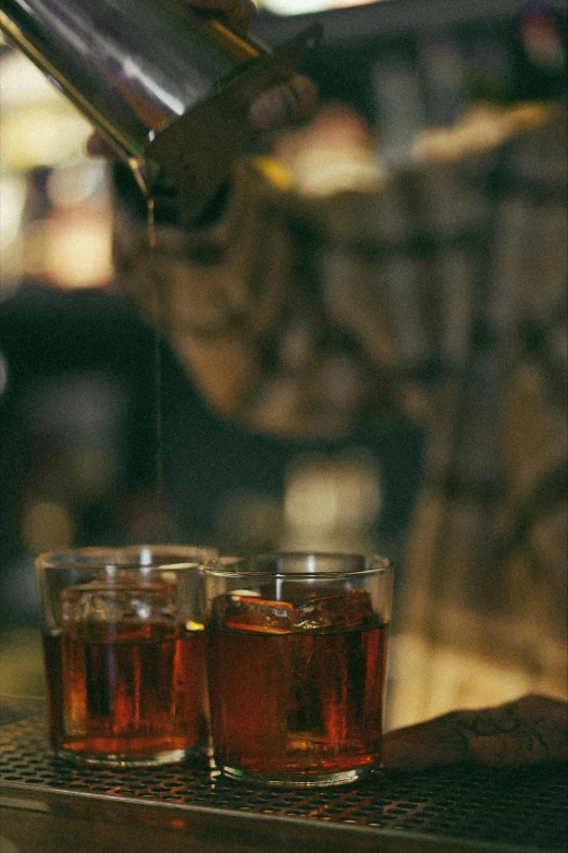 two glasses filled with liquor on a bar