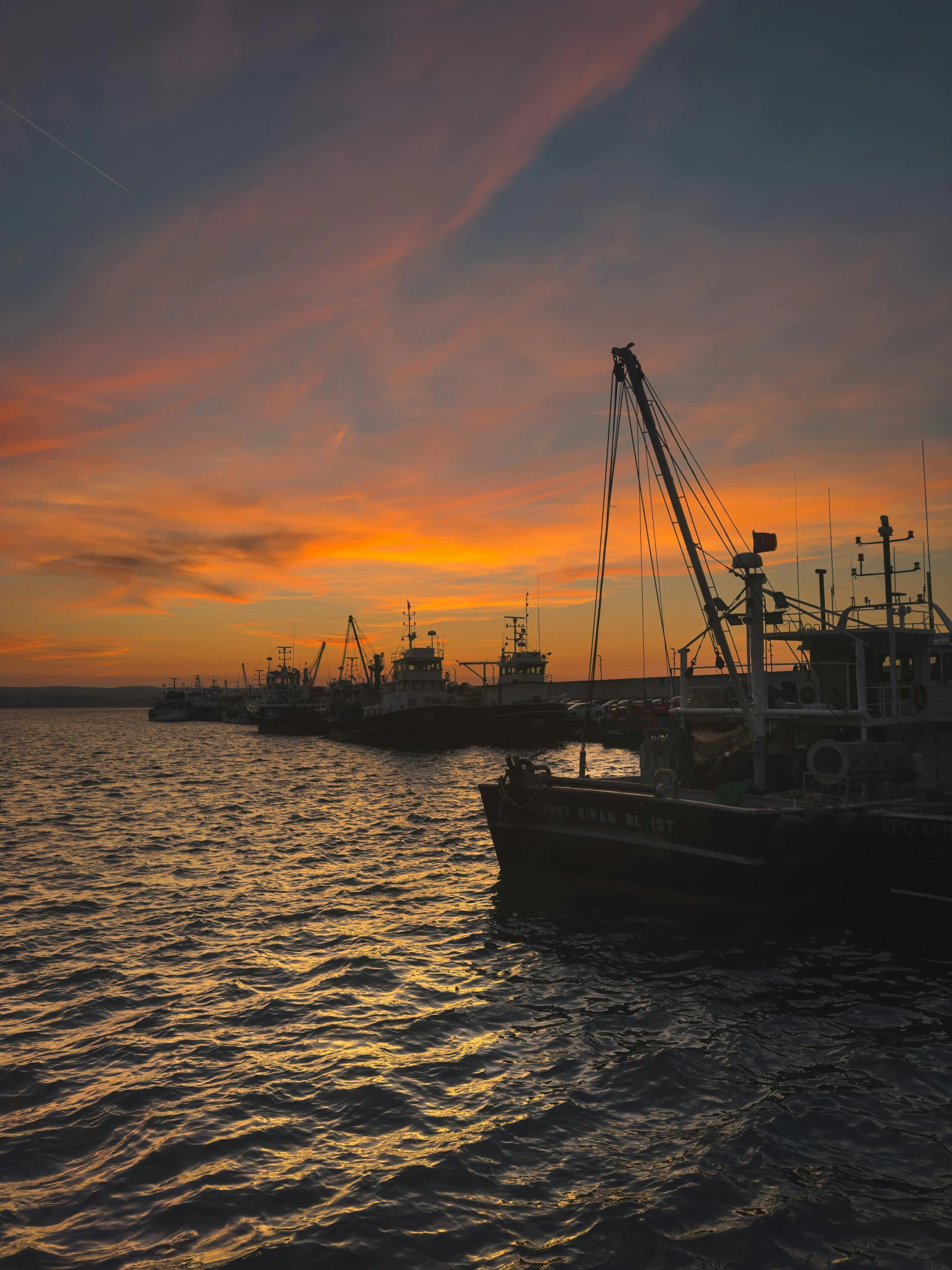 some boats docked in a bay as the sun sets