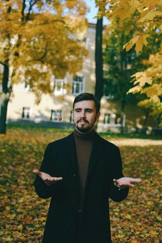 a man is posing for the camera on the leaves