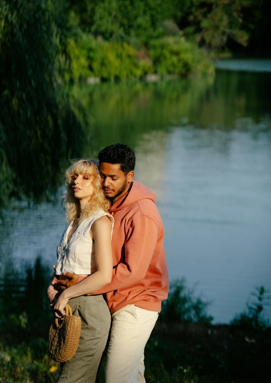 a couple hugging each other with a tree in the background