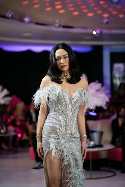 a model wears a feather covered dress in an event