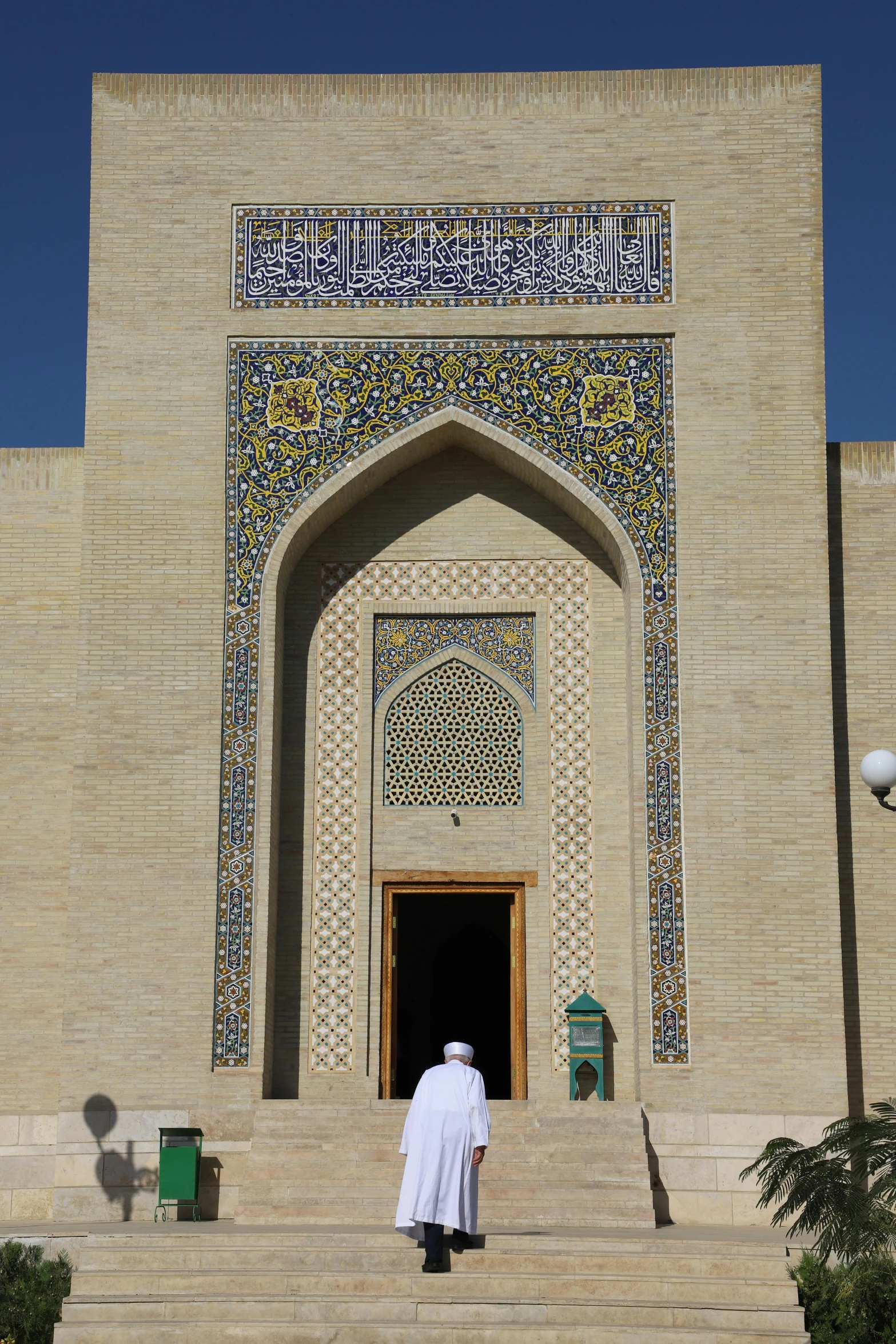 man in white standing on some steps by a building