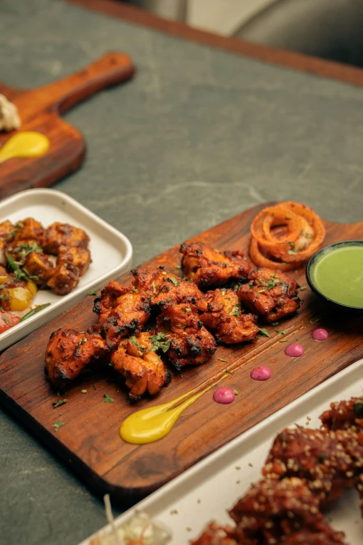 chicken with sauce and various snacks on trays