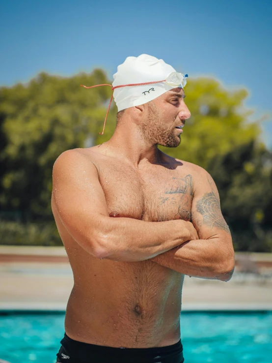 shirtless male in swimming trunks looking to the side