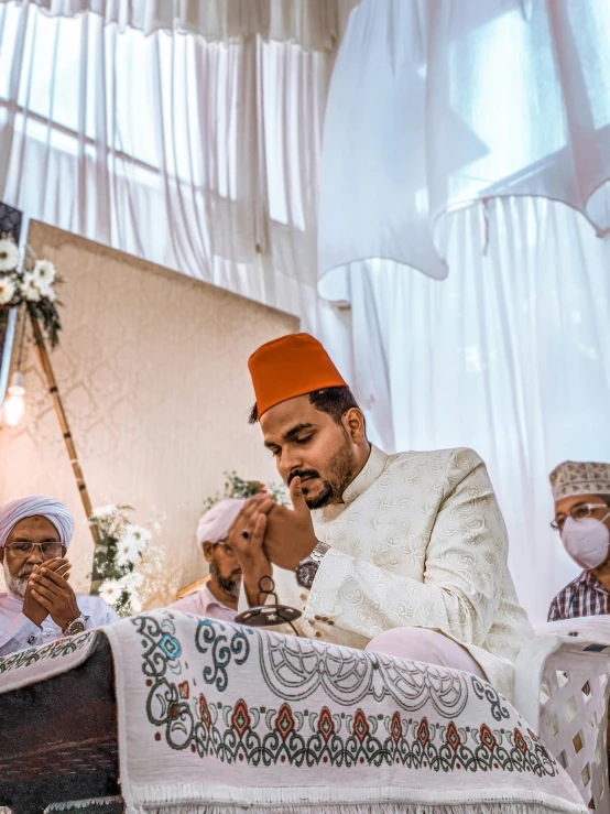 a man in a turban sitting at a alter