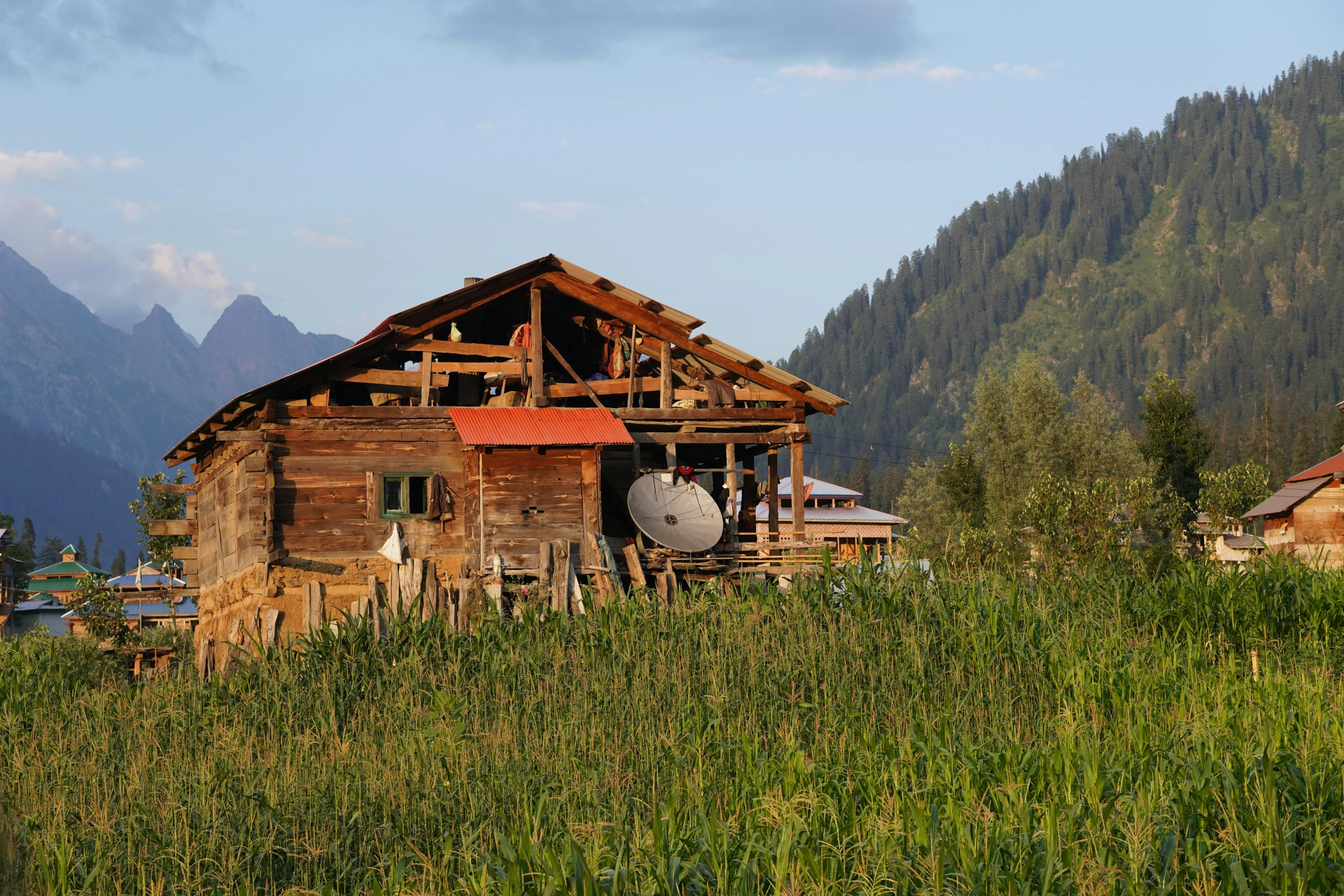 an old wooden house in the middle of a field