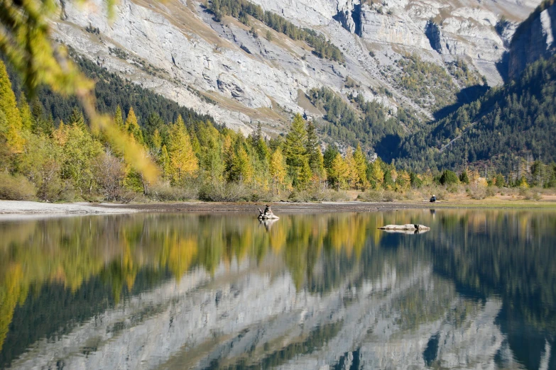 a man is fishing in a mountain lake