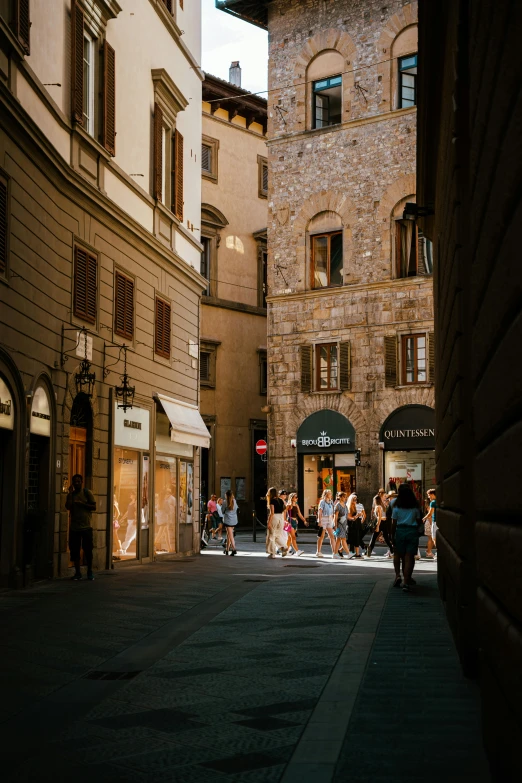 people are walking down the street in an old town