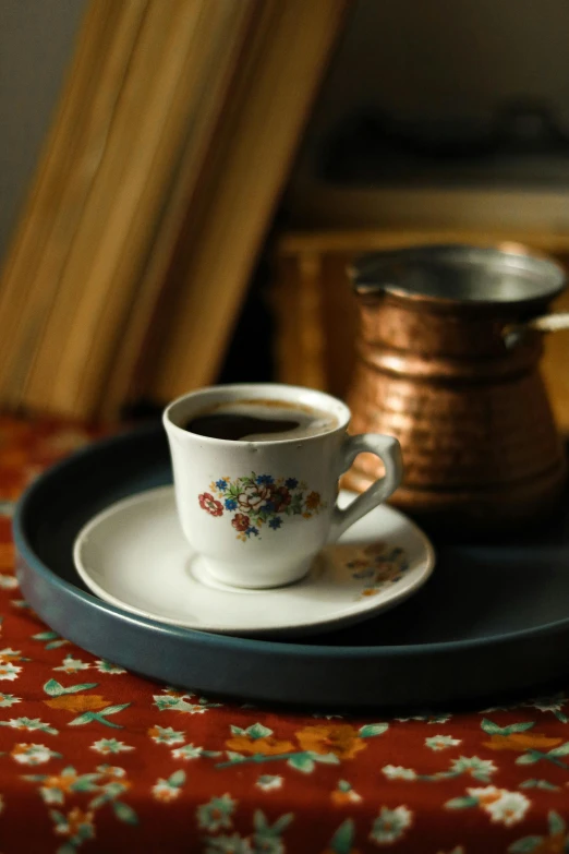 a cup and saucer are on a tray on a table