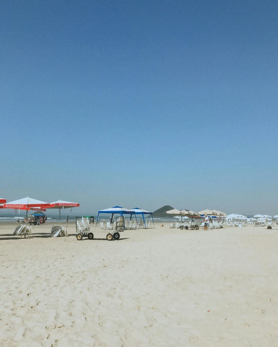 some chairs and umbrellas on a sandy beach