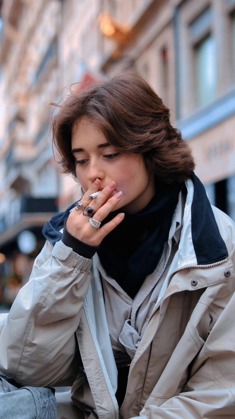 an attractive woman is smoking cigarette in the city