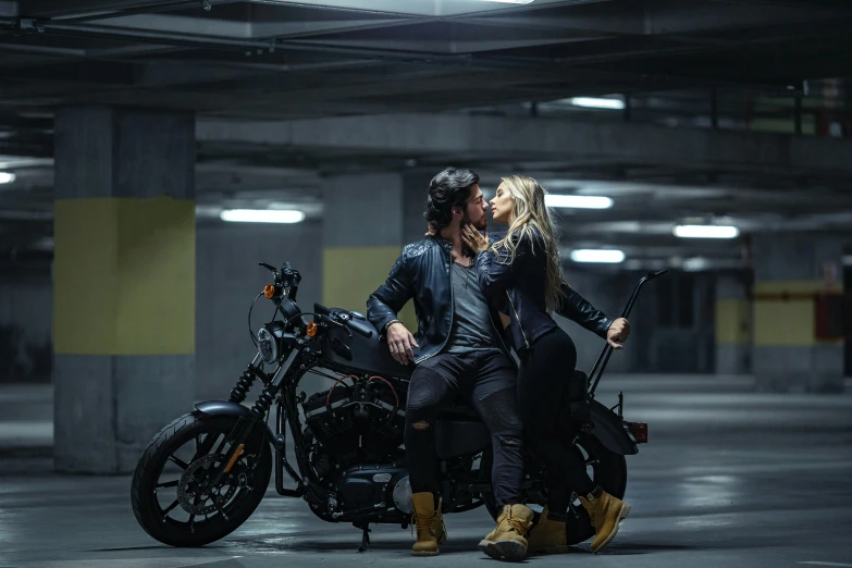 man and woman kissing while sitting on a motorcycle