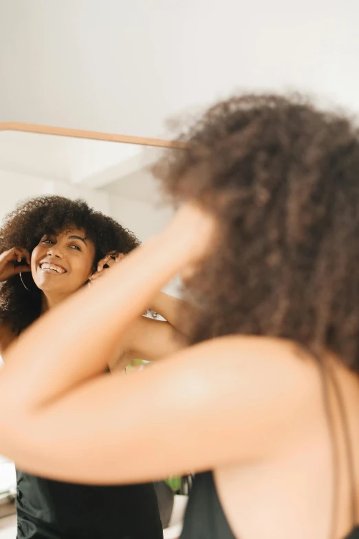 an image of a woman in the bathroom looking at herself