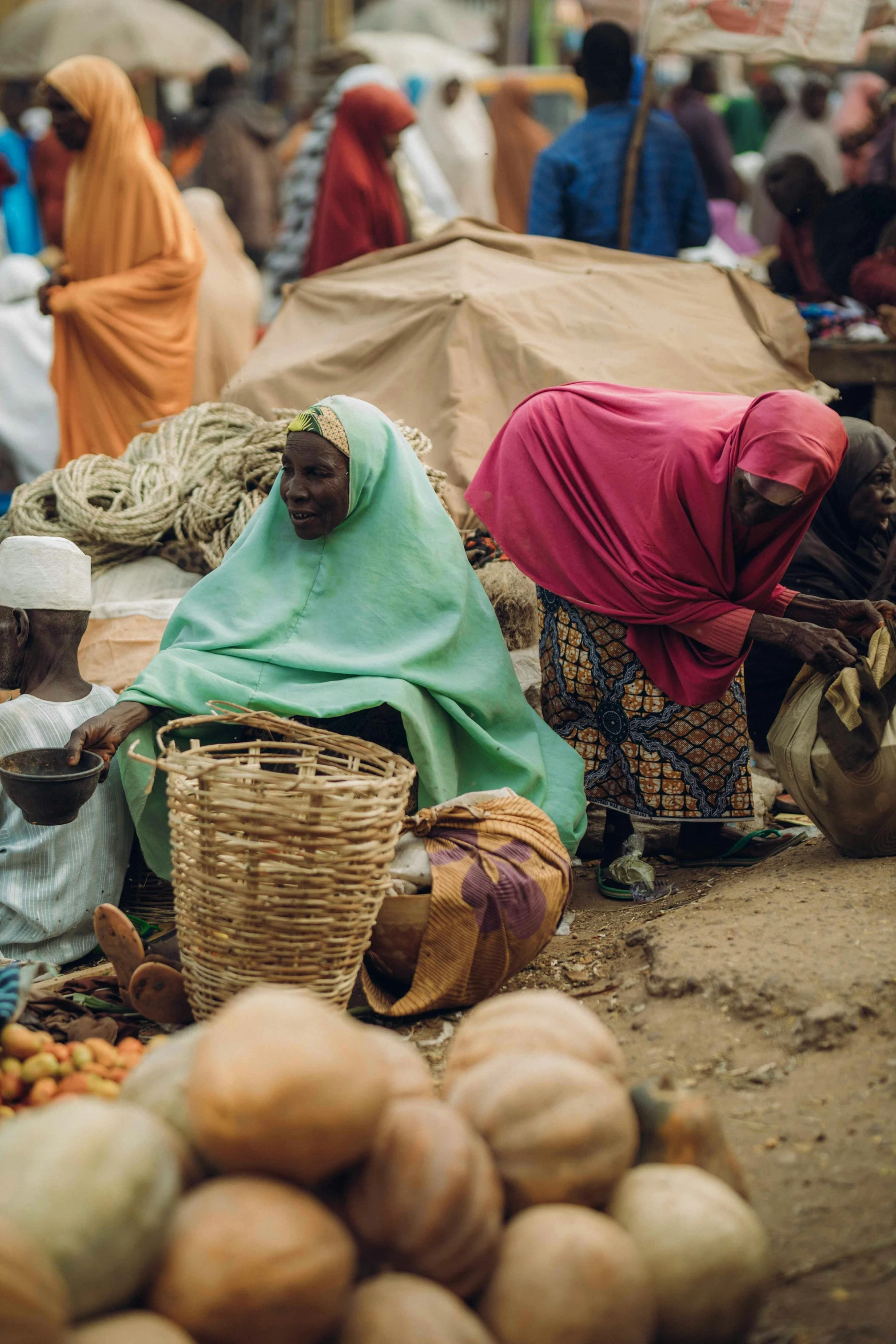 people are shopping in an open market with fruit and vegetables