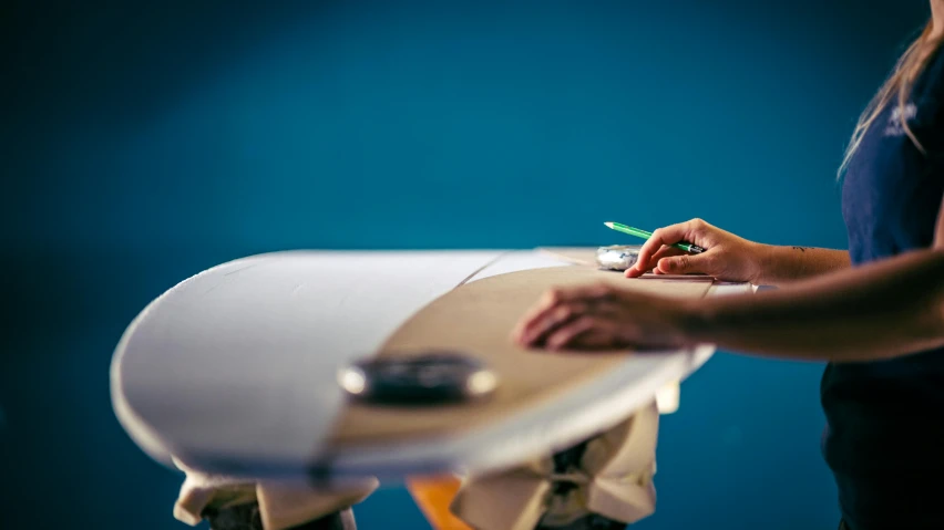 a woman using a small device to shape paper