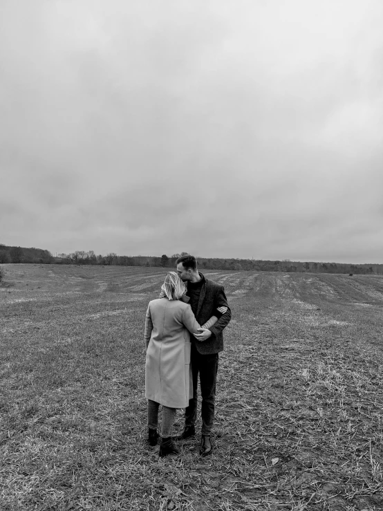 a couple is in a field with a kite