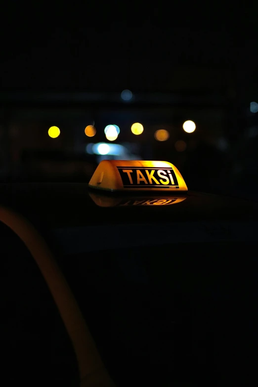 the taxi sign is yellow in the dark
