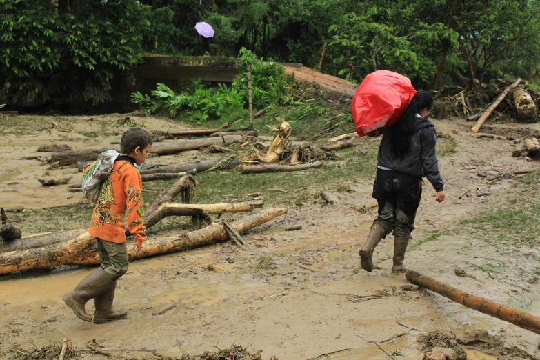 the boy is holding the red umbrella up