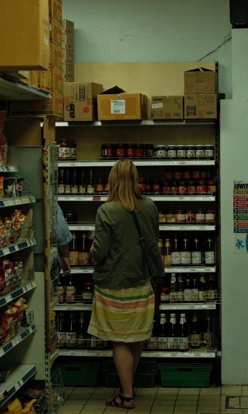 two women shop inside a deli store with canned products