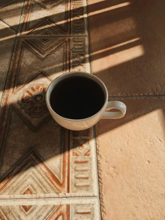 a mug of coffee sitting on a colorful area rug