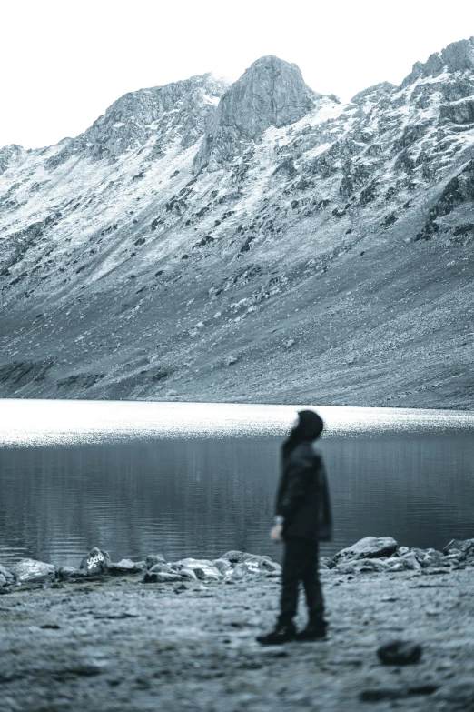 a person standing on the shore of a lake