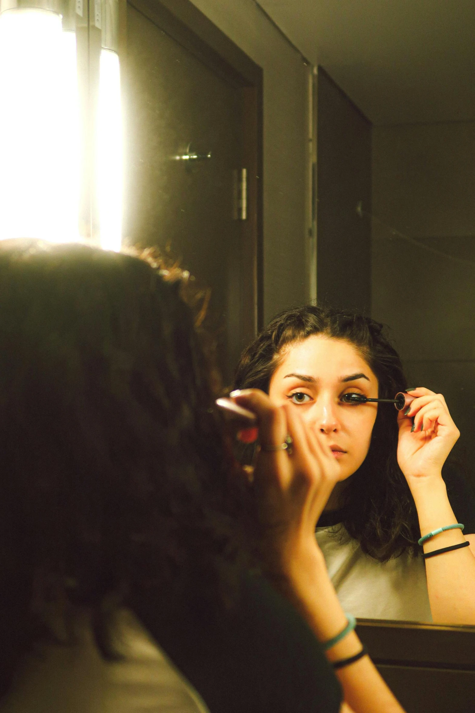 a beautiful woman brushing her teeth in front of a mirror