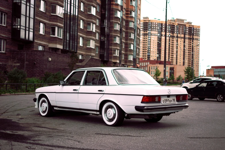 the classic bmw is parked outside the brown apartment building