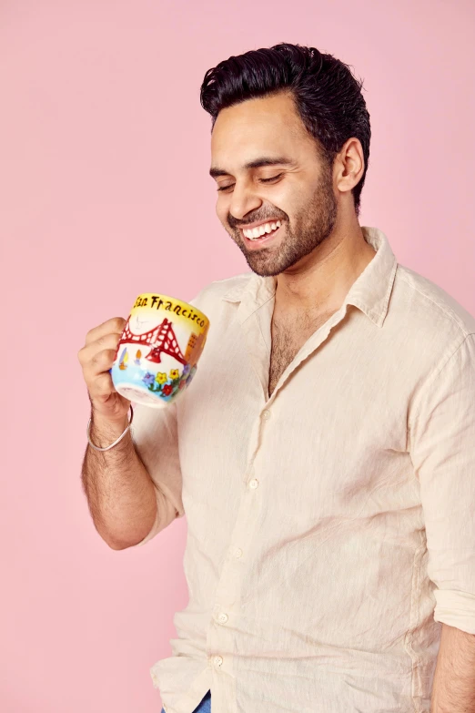 man holding birthday cake with icing on it in front of pink background