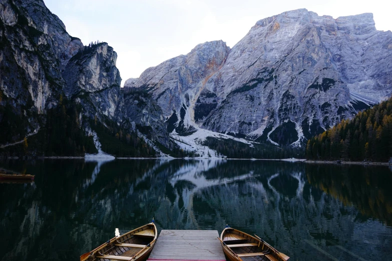 two small wooden boats sitting on top of a dock