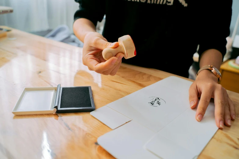 a person is stamping onto paper with a rubber