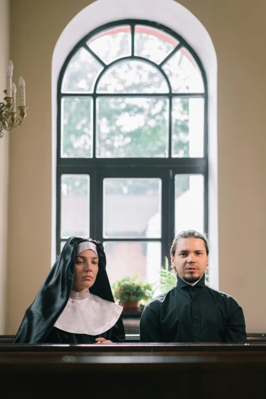 two people are sitting at a alter looking towards the camera