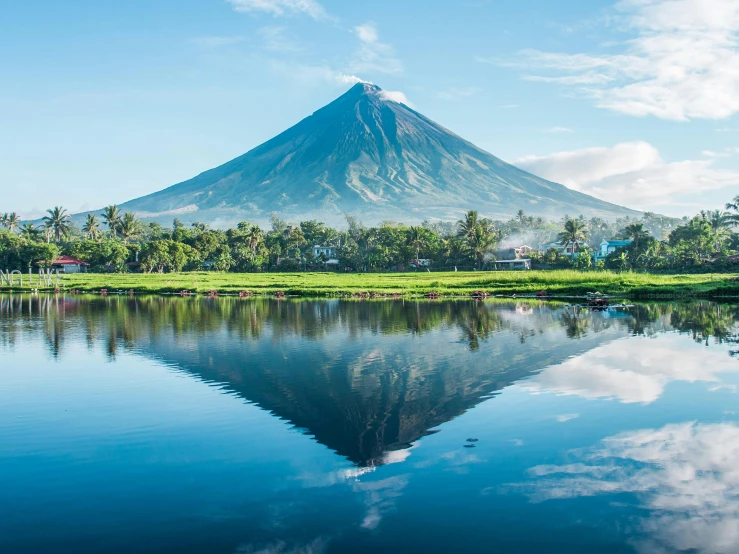 a reflection in the lake with a large mountain in the background