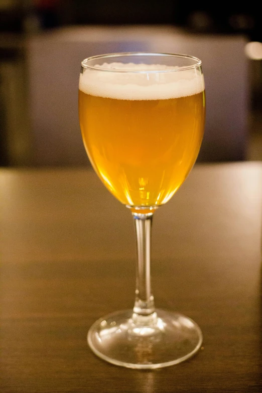 a glass full of beer sitting on a table