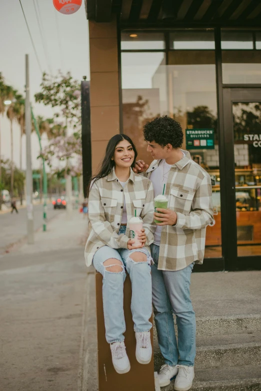 a couple sharing an outdoor coffee break while on the sidewalk