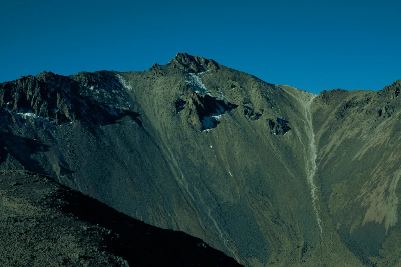 two mountains in the distance and blue sky in the background