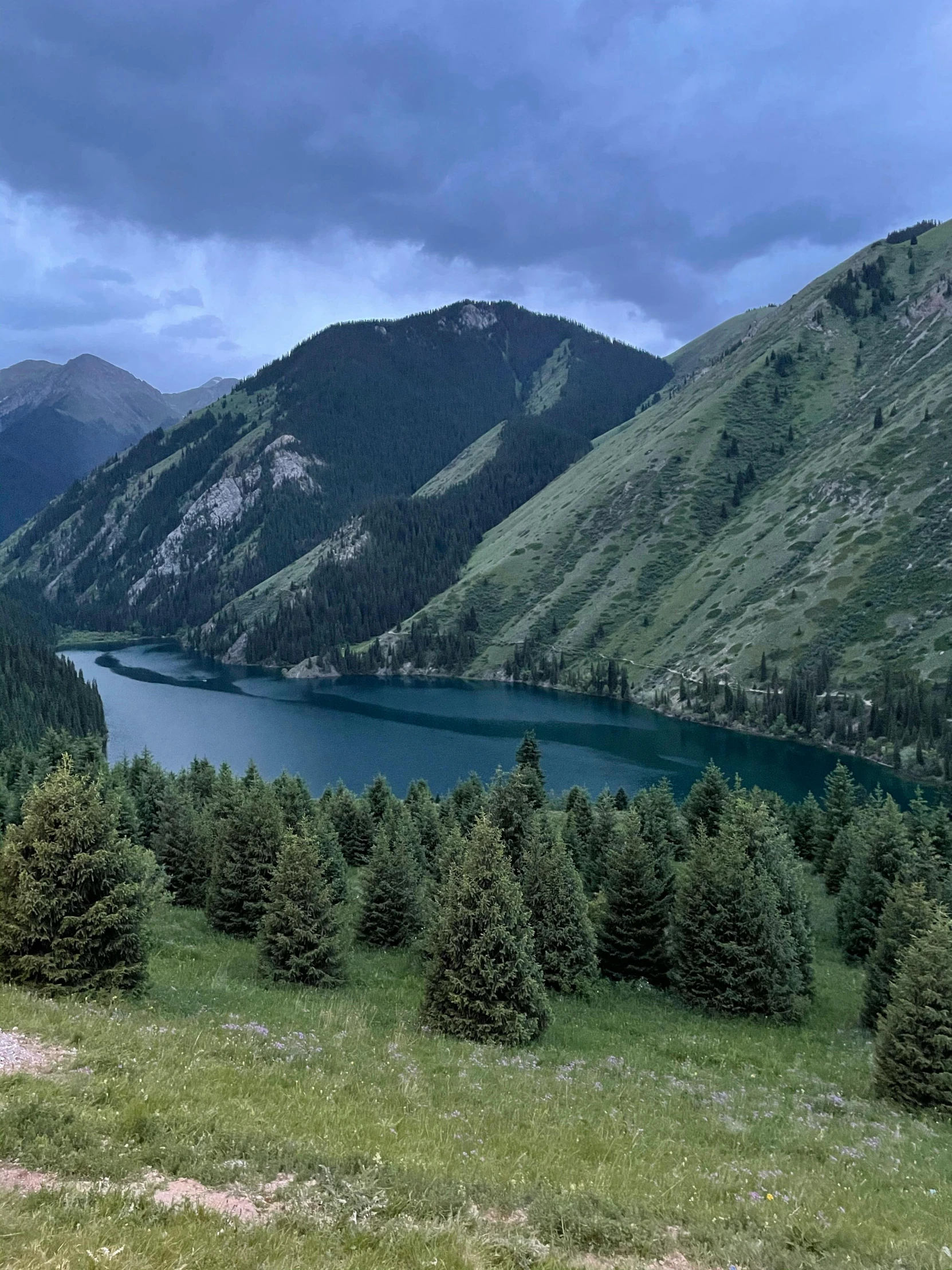 a lake surrounded by wooded hills in the distance