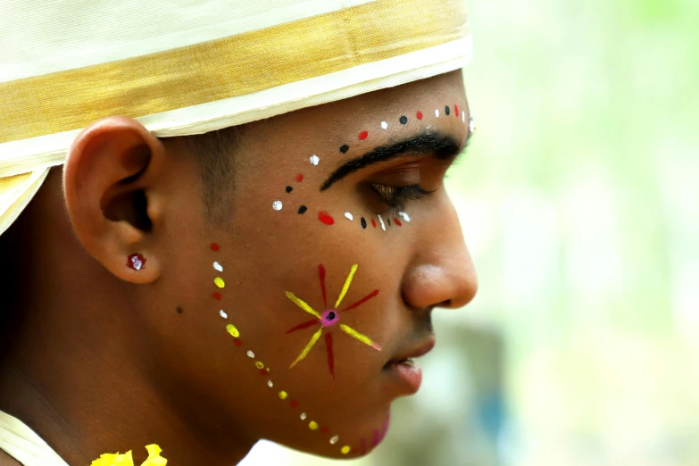 a young indian boy has some strange face paint on