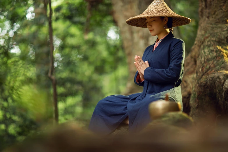 woman in a hat sitting on a stump while clapping