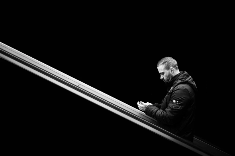 a man uses his phone on an escalator