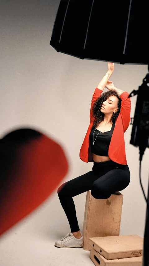 a woman in a black top, leggings and a red cardigan