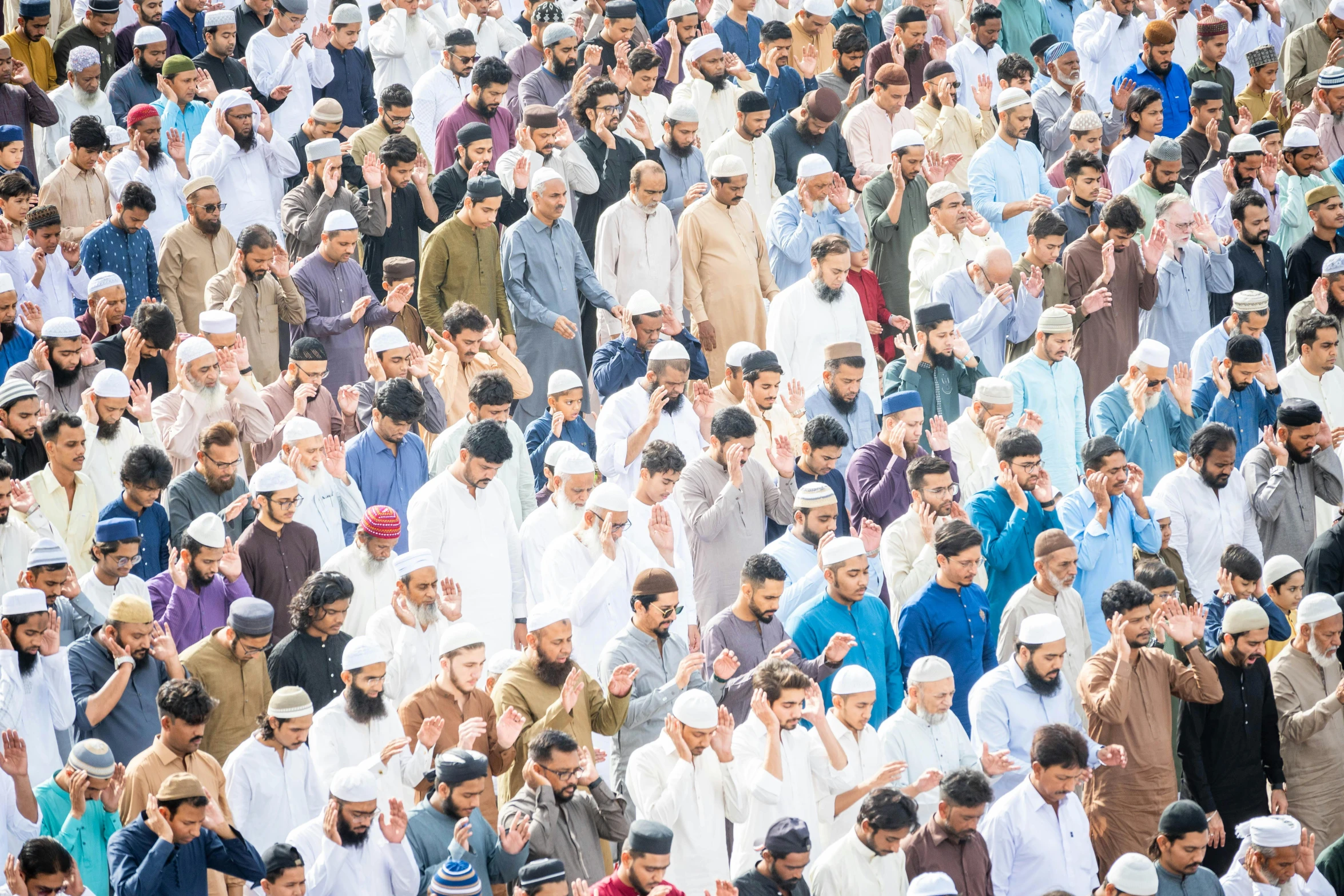 people standing in a crowd together while one holds his head to the air