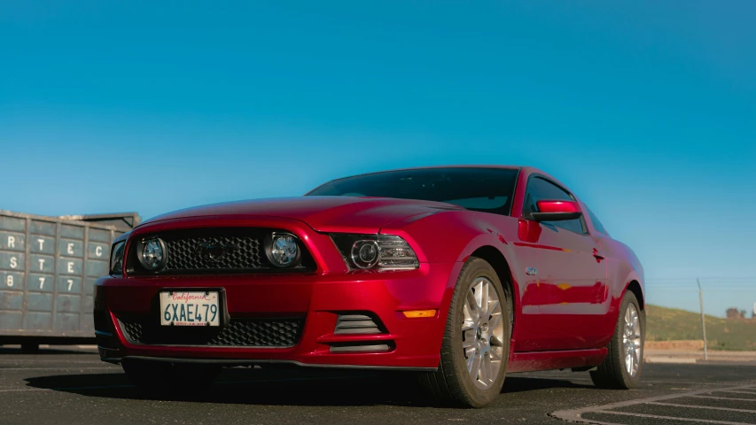 a red car is parked in the parking lot