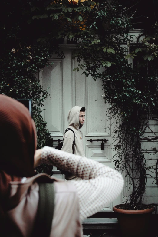 a woman sitting on a bench looking at a man in a white coat