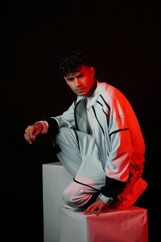 a young man poses for the camera with his hands on the cube