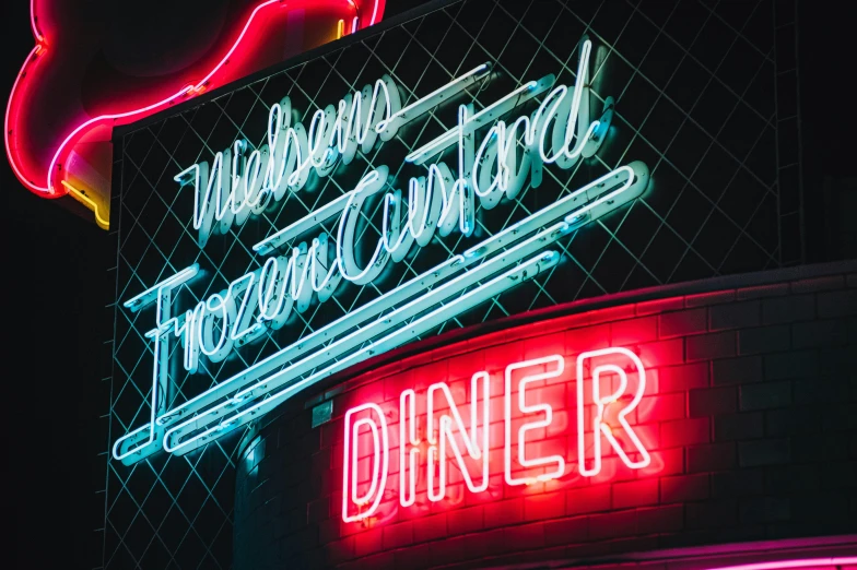 a large neon sign in a restaurant next to other neon signs