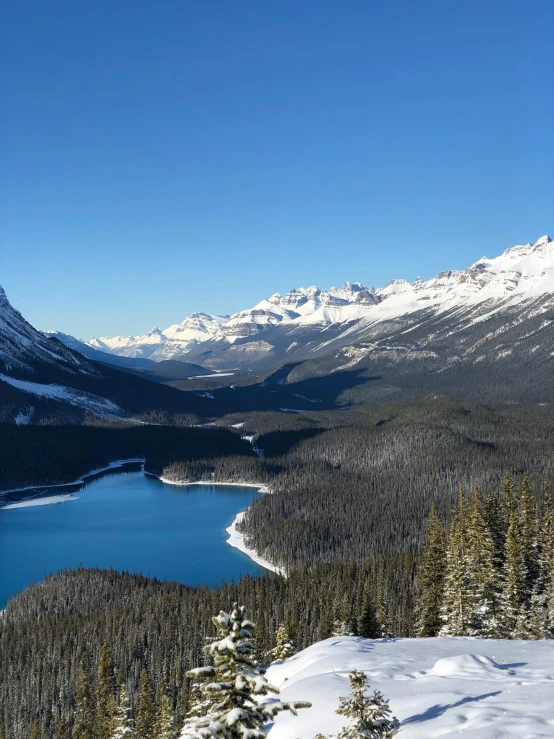 a lake is surrounded by a snowy mountain range