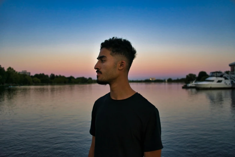 a man stands in front of a body of water