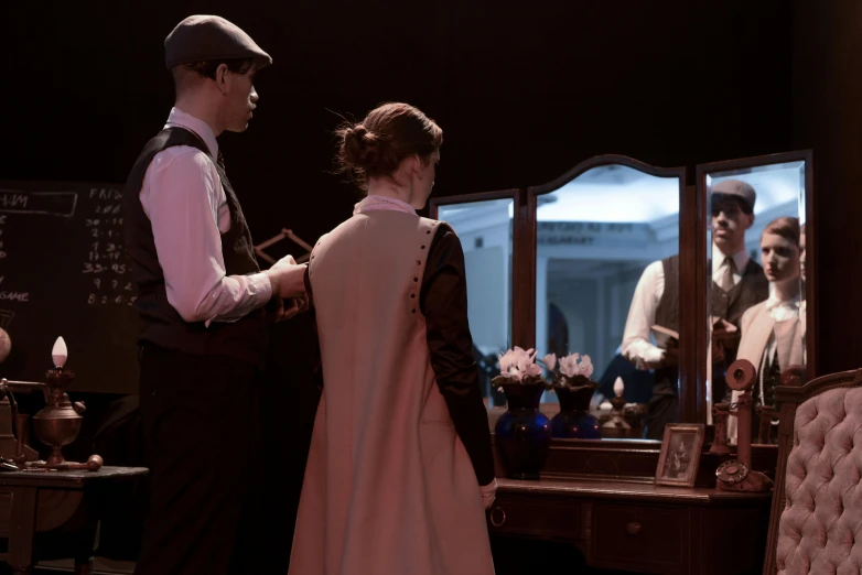 an officer helping a woman with her dress in front of a mirror