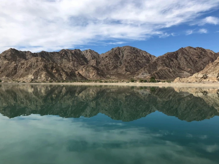 the mountains are mirrored in the still water